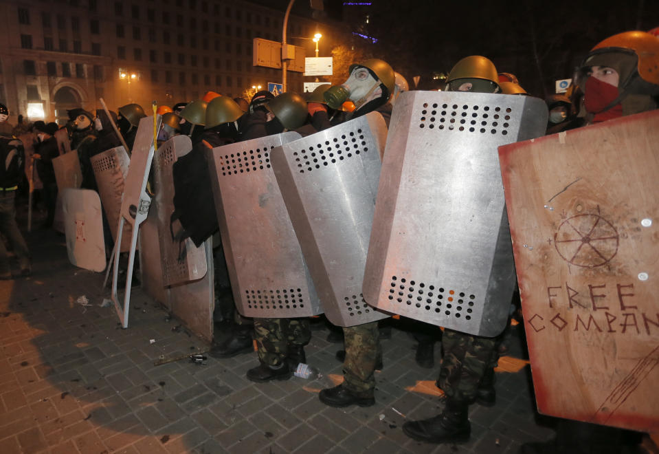 Protesters prepare to clash with riot police in central Kiev, Ukraine, Sunday, Jan. 19, 2014. Anti-government protests in Ukraine's capital escalated into fiery street battles with police Sunday as thousands of demonstrators hurled rocks and firebombs to set police vehicles ablaze. Dozens of officers and protesters were injured. The violence was a sharp escalation of Ukraine's two-month political crisis, which has brought round-the-clock protest gatherings, but had been largely peaceful. The crisis erupted in November after President Viktor Yanukovych's decision to freeze ties with the European Union and seek a huge bailout from Russia (AP Photo/Efrem Lukatsky)