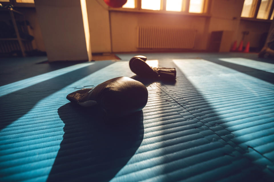 Pair of boxing gloves lying on floor in an empty gym