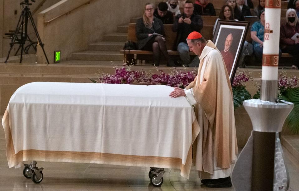 Cardinal Roger Mahony prays over the casket