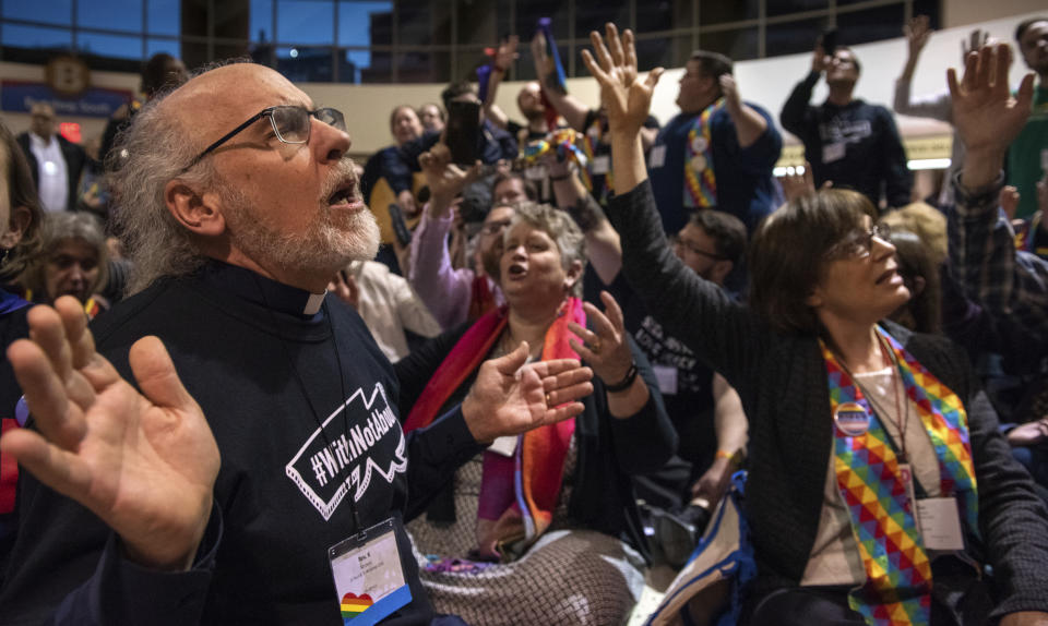 FILE - The Rev. K Karen, left, of St. Paul & St. Andrew United Methodist Church in New York joins other protesters in song and prayer outside the United Methodist Church's special session of the general conference in St. Louis, Tuesday, Feb. 26, 2019. Since 2019, the denomination has lost about one-fourth of its U.S. churches in breakup focused in large part on whether to accept same-sex marriage and ordination of LGBT clergy. (AP Photo/Sid Hastings, File)