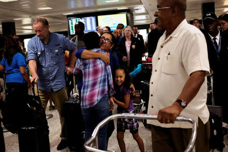 Family members greet international passengers as they arrive at Dulles International Airport in Dulles, Virginia, U.S. September 24, 2017. REUTERS/James Lawler Duggan