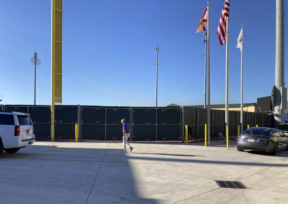 Major League Baseball Commissioner Rob Manfred walks at Roger Dean Stadium in Jupiter, Fla. Friday, Feb. 25, 2022, during MLB labor negotiations. (AP Photo/Ron Blum)