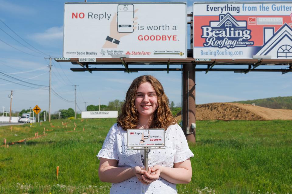 Sadie Bradley, 10th grade student at South Western High School, poses for a portrait during an unveiling of her winning distracted driving billboard design along Carlisle Pike, Tuesday, April 30, 2024, in Hanover.
