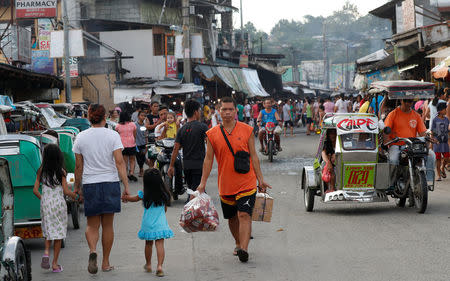 Residents walk along a street in Barangay Payatas district in Quezon City, Metro Manila in the Philippines December 11, 2017. REUTERS/Erik De Castro