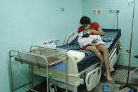 Ada Mendoza, 24, breastfeeds her newborn daughter Peyton for the first time at the Hugo Chavez Frias Public Maternity and Children's Hospital in the El Valle neighborhood of Caracas, Venezuela, early Thursday, Sept. 10, 2020. Her partner, Leo Camejo, was not allowed to witness his daughter’s birth due to virus-related sanitary restrictions at the free maternity hospital, where thousands like them can’t afford the thousand dollars price tags of private clinics. (AP Photo/Matias Delacroix)