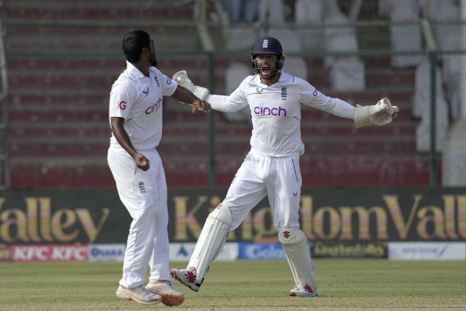 England's Ben Foakes, right, and Rehan Ahmed celebrates after the dismissal of Pakistan's Mohammad Rizwan, center, during the third day of third test cricket match between England and Pakistan, in Karachi, Pakistan, Monday, Dec. 19, 2022. (AP Photo/Fareed Khan)