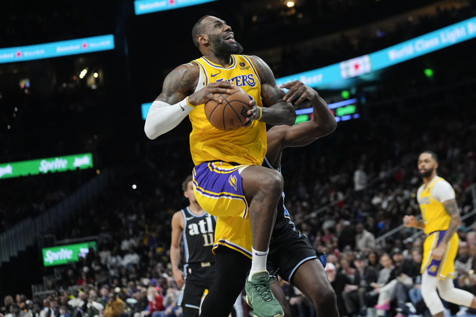Los Angeles Lakers forward LeBron James (23) goes past Atlanta Hawks center Clint Capela (15) as he scores a basket in the second half of an NBA basketball game Tuesday, Jan. 30, 2024, in Atlanta. (AP Photo/John Bazemore)