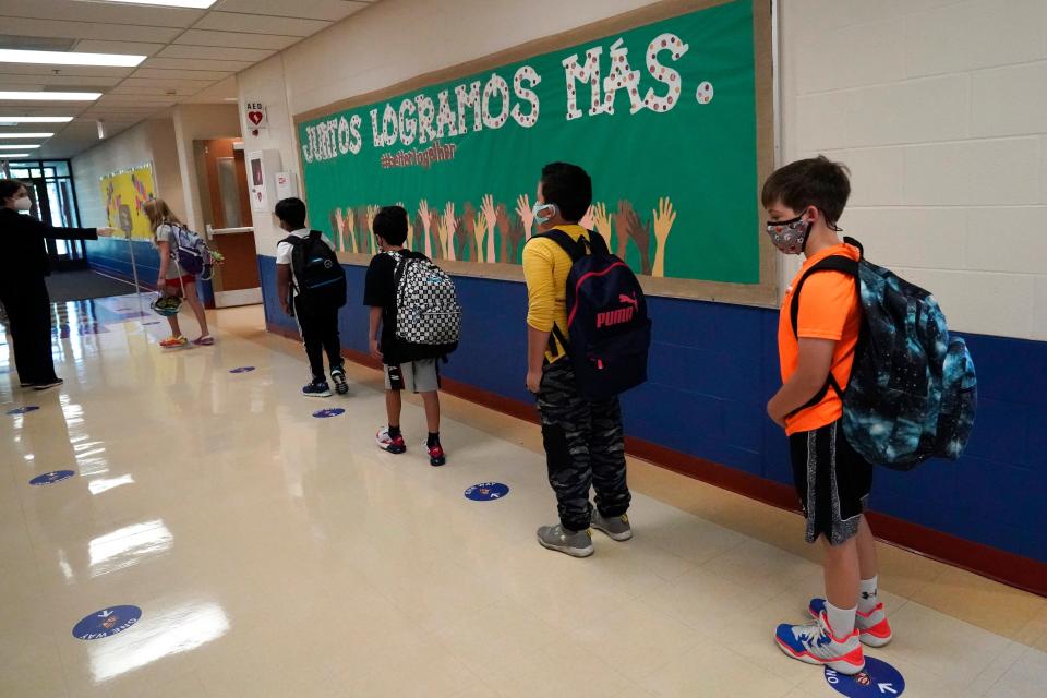 Students keep social distance as they walk to their classroom.