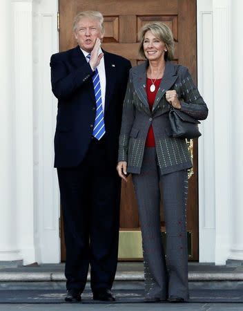 U.S. President-elect Donald Trump (L) stands with Betsy DeVos after their meeting at the main clubhouse at Trump National Golf Club in Bedminster, New Jersey, U.S., November 19, 2016. REUTERS/Mike Segar/File Photo
