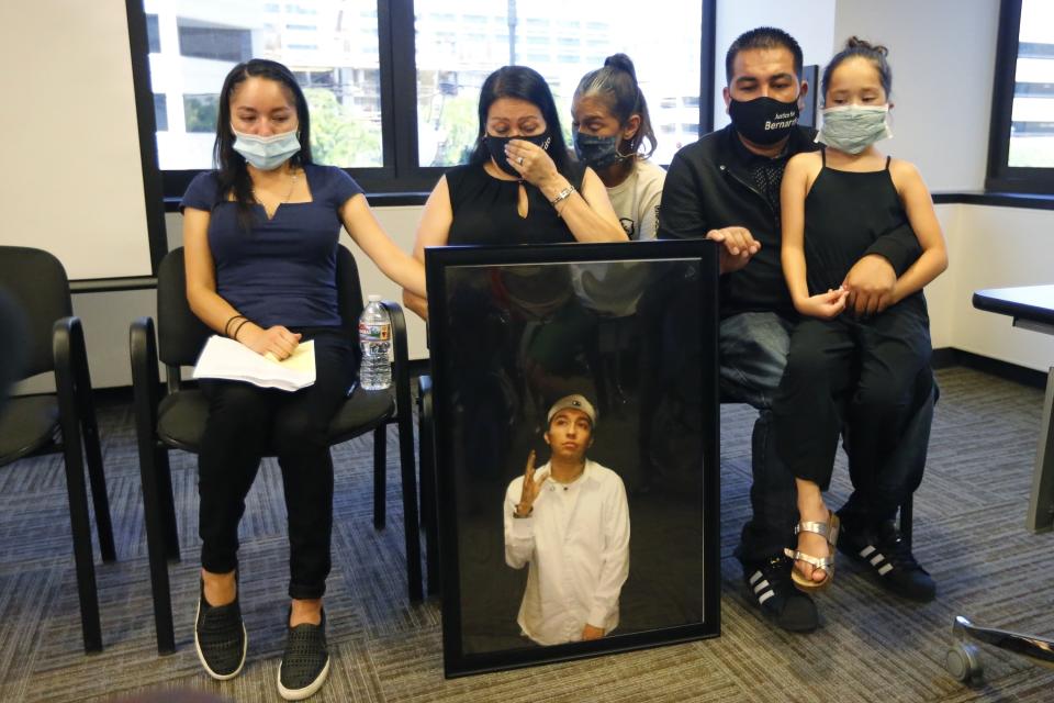 FILE - In this Thursday, July 9, 2020, file photo, Lucy Carbajal, center left, sits behind a photograph of her son Bernardo Palacios-Carbajal while other family members look on during a news conference at their attorney's office in Salt Lake City. A federal judge on Monday, Feb. 28, 2022, has dismissed a wrongful death lawsuit filed by the family of Palacios-Carbajal, who was shot at nearly 30 times and killed as he ran away from Salt Lake City police in 2020. (AP Photo/Rick Bowmer, File)