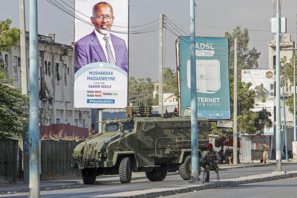 Security forces block a street with an armored personnel carrier during protests against the government and the delay of the country's election in the capital Mogadishu, Somalia Friday, Feb. 19, 2021. Security forces in Somalia's capital fired on hundreds of people protesting the delay of the country's election on Friday as at least one explosion was reported at the international airport and armored personnel carriers blocked major streets. (AP Photo)
