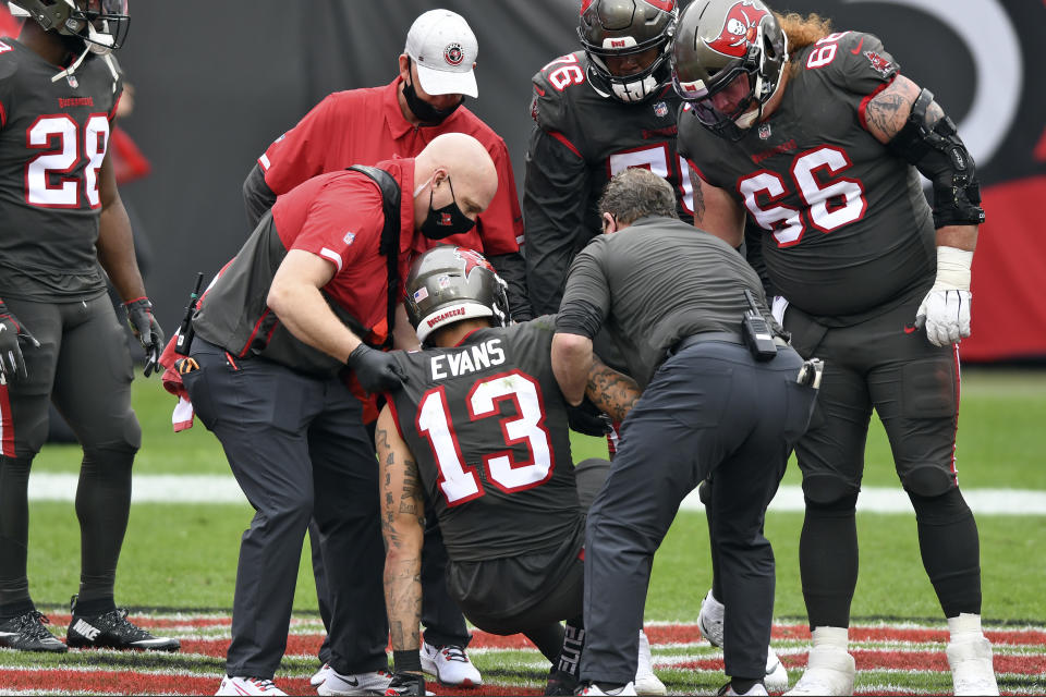 Tampa Bay Buccaneers wide receiver Mike Evans (13) is helped to his feet after getting injured against the Atlanta Falcons during the first half of an NFL football game Sunday, Jan. 3, 2021, in Tampa, Fla. Evans left the game. (AP Photo/Jason Behnken)