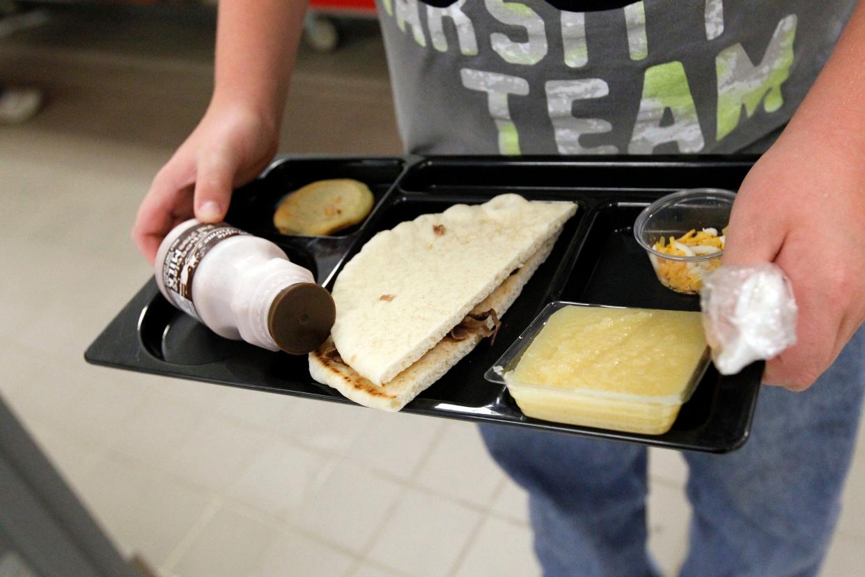 FILE - In this Wednesday, Sept. 12, 2012 file photo, a student at Eastside Elementary School in Clinton, Miss., holds a school lunch served under federal standards, consisting of a flatbread roast beef sandwich, apple sauce, chocolate milk and a cookie. After just one year, some schools across the nation are dropping out of what was touted as a healthier federal lunch program, complaining that so many students refused the meals packed with whole grains, fruits and vegetables that their cafeterias were losing money. (AP Photo/Rogelio V. Solis, File) ORG XMIT: NYR201