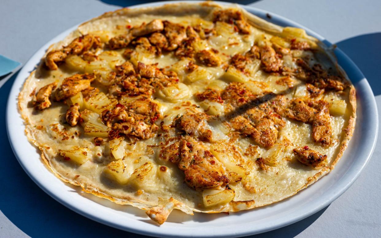 Savory piri piri pancake with pineapple and grilled seasoned chicken served in a restaurant