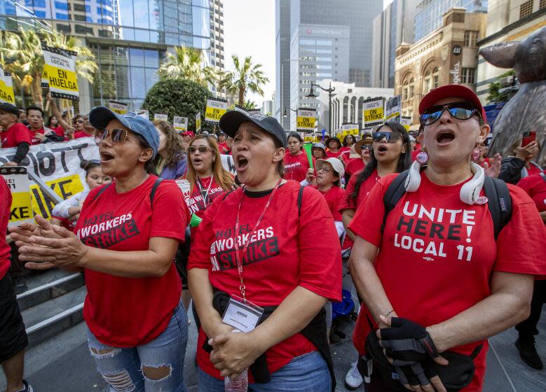LOS ANGELES, CA-AUGUST 7, 2023:left to right-Eliza Silva, Lorena Ramirez, and Maria Hernandez, hotel workers at the JW Marriott hotel in downtown Los Angeles, join other striking hotel workers during a protest outside the InterContinental Los Angeles Downtown hotel, at the intersection of 7th St. and Figueroa in downtown Los Angeles. The union has filed a formal complaint after a series of violent incidents involving security at three hotels in L.A. and Orange. counties. (Mel Melcon / Los Angeles Times)