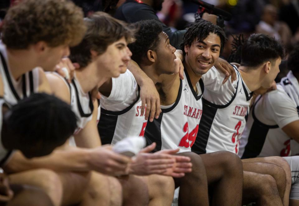 Orchard Lake St. Mary's Aiden Hanks (24) smiles as he puts his arms around his teammates during a 63-52 win against North Farmington at the MHSAA Div. 1 state finals inside the Breslin Center in East Lansing on Saturday, March 16, 2024.