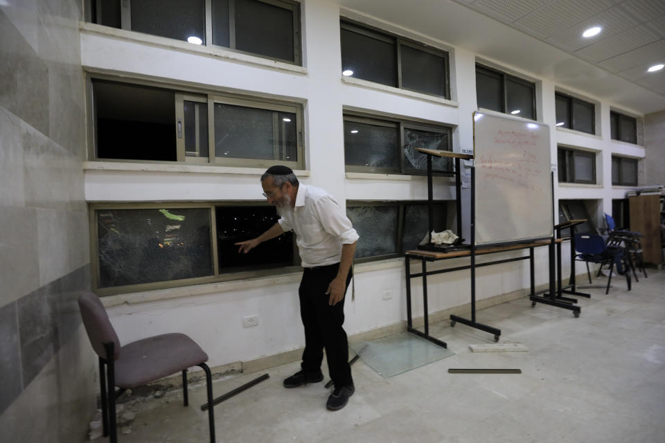 A rabbi stands inside a Jewish religious school in Sderot, Israel, after it was hit by a rocket fired from the Gaza Strip, Thursday, June 13, 2019. (AP Photo/Tsafrir Abayov)