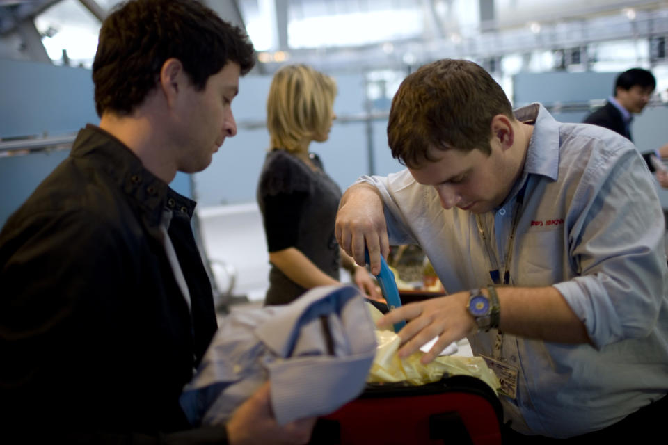 FILE - In this Tuesday, Nov. 2, 2010 file photo, a passenger has his luggage checked by security personnel, inside the Ben Gurion airport terminal, near Tel Aviv, Israel. In a modern twist on Israel's vaunted history of airport security, the country has begun forcing incoming travelers deemed suspicious to open their personal e-mail accounts for inspection. (AP Photo/Ariel Schalit, File)