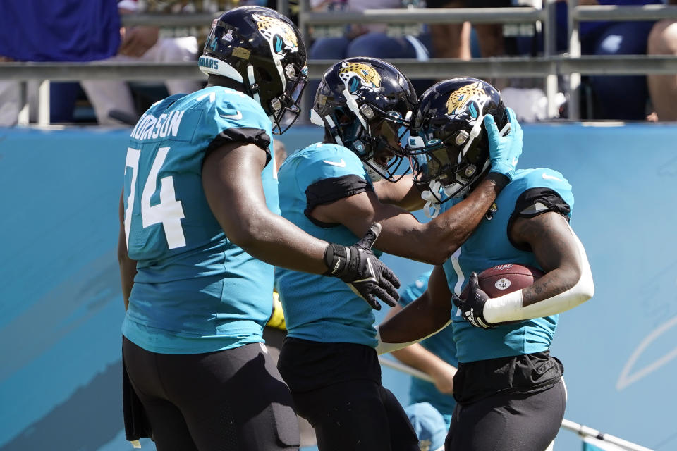 Jacksonville Jaguars running back Travis Etienne Jr. (1, right) celebrates with teammates, including offensive tackle Cam Robinson (74) after scoring against the New York Giants during the first half of an NFL football game Sunday, Oct. 23, 2022, in Jacksonville, Fla. (AP Photo/John Raoux)