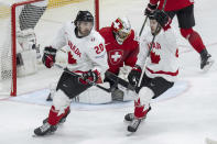 Canada's Nick Paul, left, and Canada?s Andrew Mangiapane, right, celebrate after their goal against Switzerland goalkeeper Leonardo Genoni, center, during the Ice Hockey World Championship group A preliminary round match in Prague, Czech Republic, Sunday, May 19, 2024. (Peter Schneider/Keystone via AP)