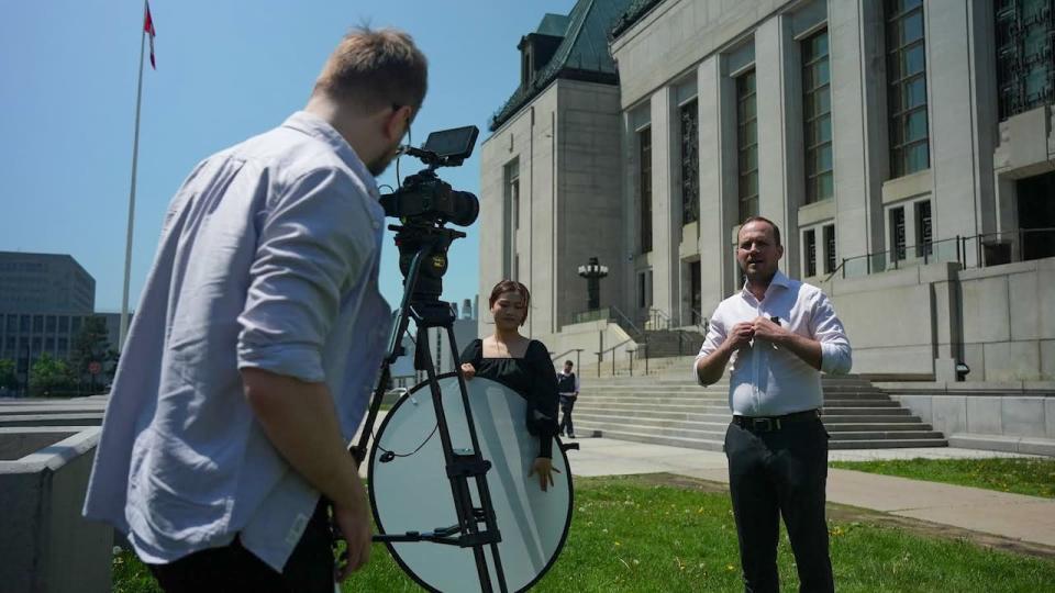 Liberal MP Nate Erskine-Smith filming a social media video with new hire filmmaker Kristian Podlacha in front of the Supreme Court.