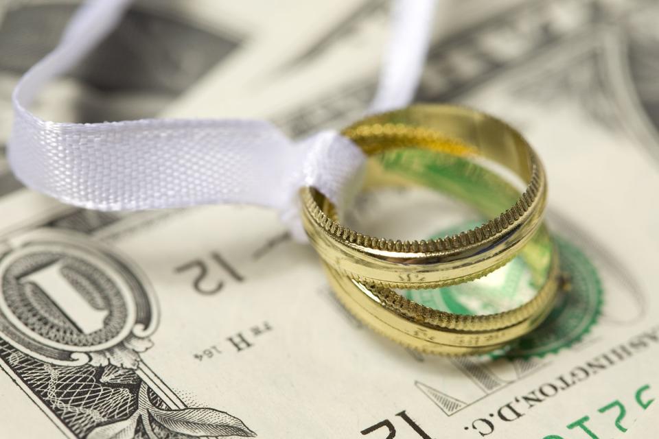 <p>Getty Images</p> Stock image of wedding ring and cash