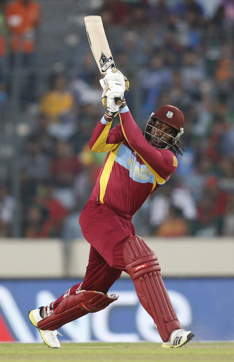 West Indies' batsman Chris Gayle watches his shot during the ICC Twenty20 Cricket World Cup match against Australia in Dhaka, Bangladesh, Friday, March 28, 2014. (AP Photo/Aijaz Rahi)