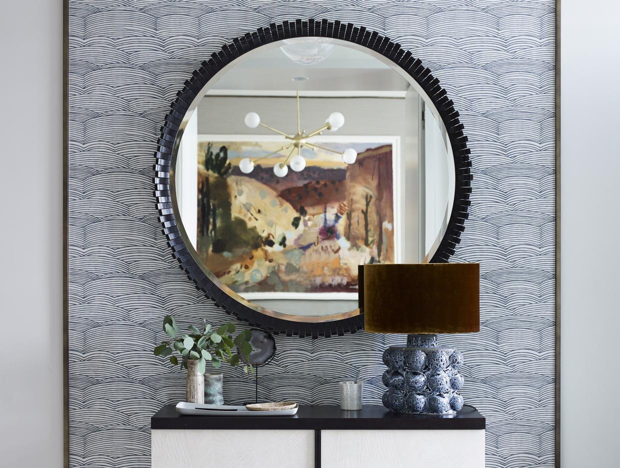  Entryway with wallpaper and circular mirror. 