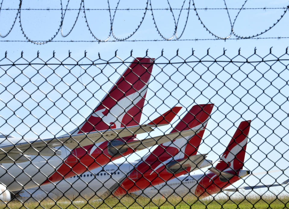 Grounded Qantas aircraft are seen parked at Brisbane Airport in Brisbane, Friday, April 17, 2020. The Australian government has forced airline carriers to cut both their domestic and international flights in order to slow the spread of the coronavirus (COVID-19) disease. (AAP Image/Darren England) NO ARCHIVING