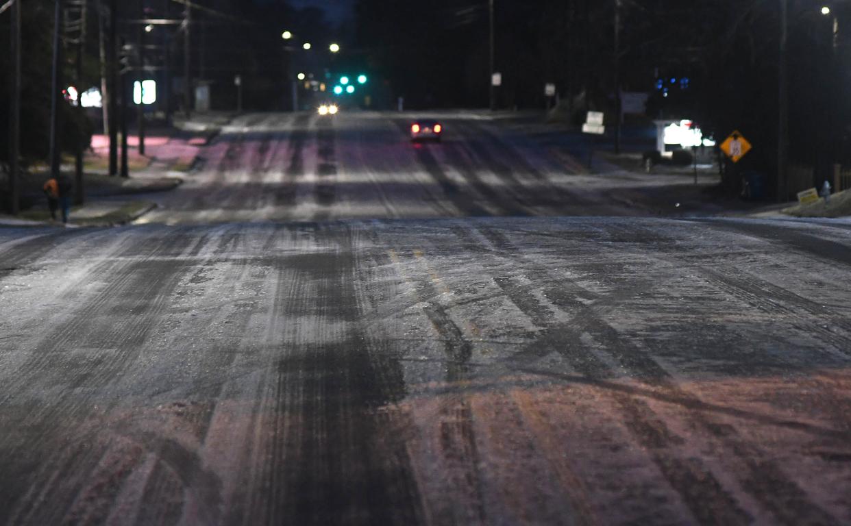 Cars drive along Market St. early in the morning in Wilmington, N.C., Saturday Jan. 22, 2022. A wintry mix fell throughout the night over the Wilmington area and created dangerous conditions.    [MATT BORN/STARNEWS]