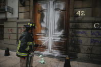 A firefighter sprays down a door that was lit on fire by protestors during a protest in Mexico City, Saturday Sept. 28, 2019. Women marched the streets of Mexico City on Saturday to bring awareness to women and pro abortion rights. (AP Photo/Anthony Vazquez)