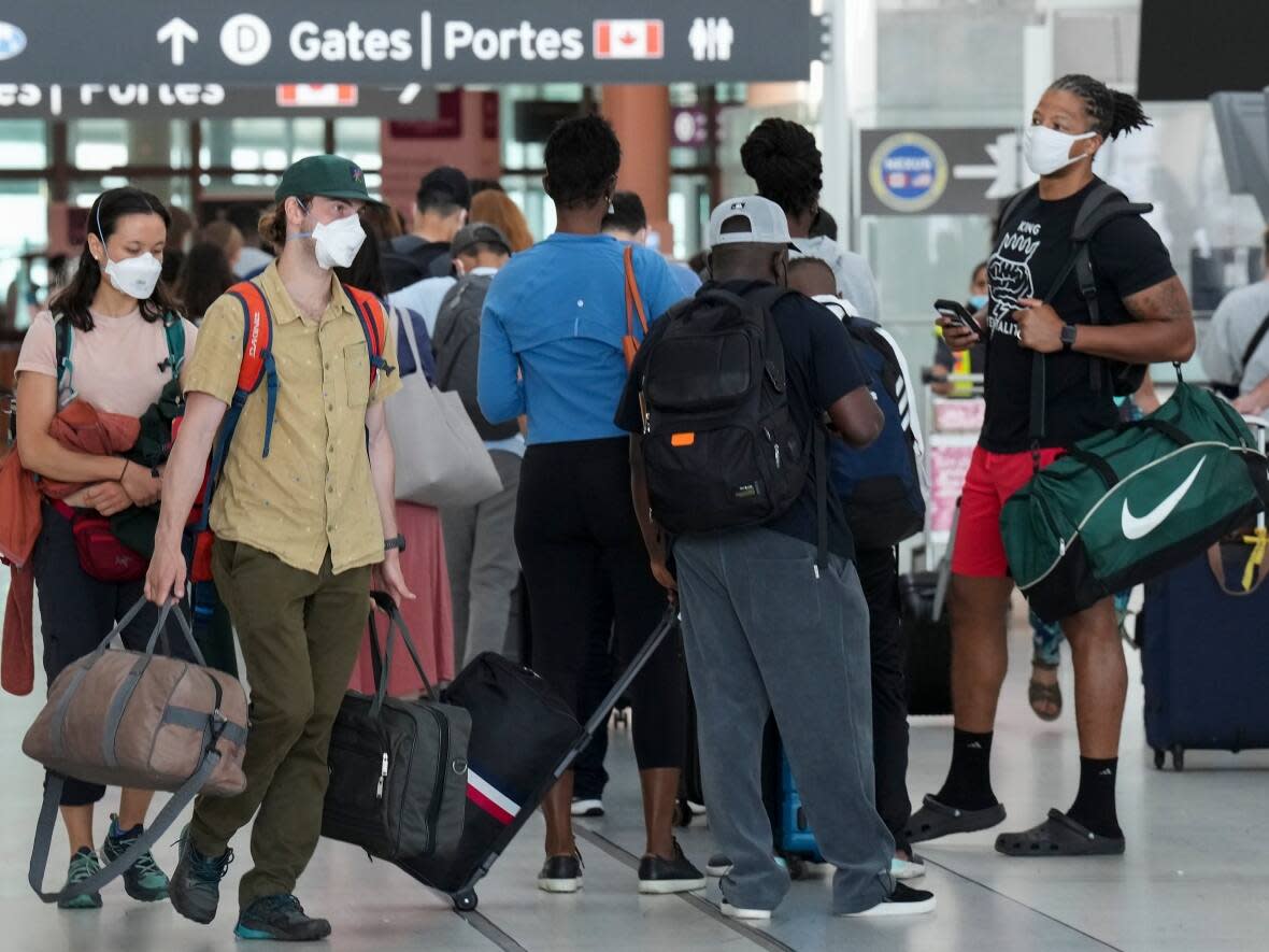 People line up before entering security at Pearson International Airport in Toronto earlier this month. (THE CANADIAN PRESS - image credit)