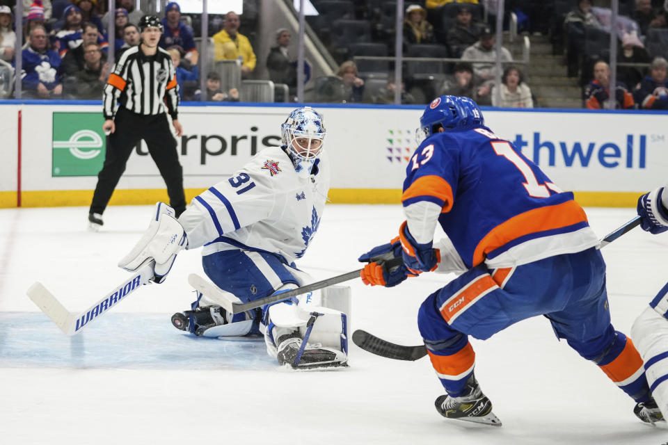 New York Islanders' Mathew Barzal (13) shoots the puck past Toronto Maple Leafs goaltender Martin Jones (31) for the winning goal during the overtime period of an NHL hockey game Thursday, Jan. 11, 2024, in Elmont, N.Y. (AP Photo/Frank Franklin II)