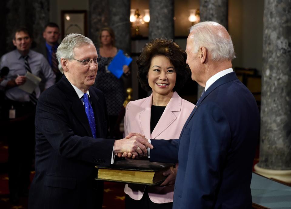 Vice President Joe Biden shakes hands with Senate Majority Leader Mitch McConnell of Ky. after Biden administered the Senate oath during a ceremonial re-enactment swearing-in ceremony, Tuesday, Jan. 6, 2015, in the Old Senate Chamber on Capitol Hill in Washington. McConnell's wife, former Labor Secretary Elaine Chao is at center. (AP Photo/Susan Walsh)