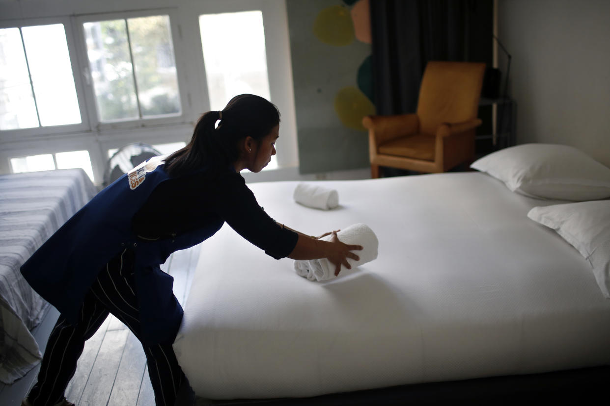In this Thursday, Sept. 20, 2018 photo, a cleaning lady works in an apartment located on Airbnb in Paris. Airbnb said Thursday, Oct. 8, 2020 it will require hosts to comply with enhanced cleaning procedures as part of its effort to reassure guests and local officials during the coronavirus pandemic. (AP Photo/Thibault Camus, file)