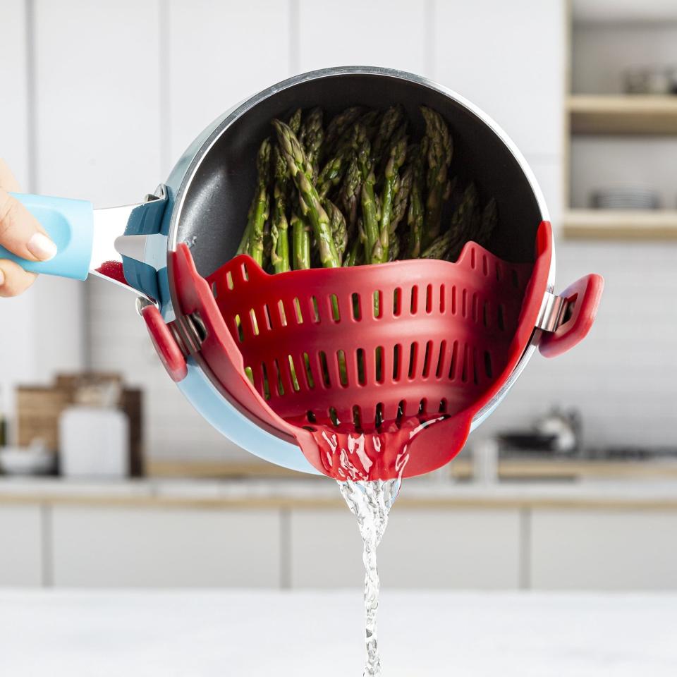 Model straining asparagus in a blue pot