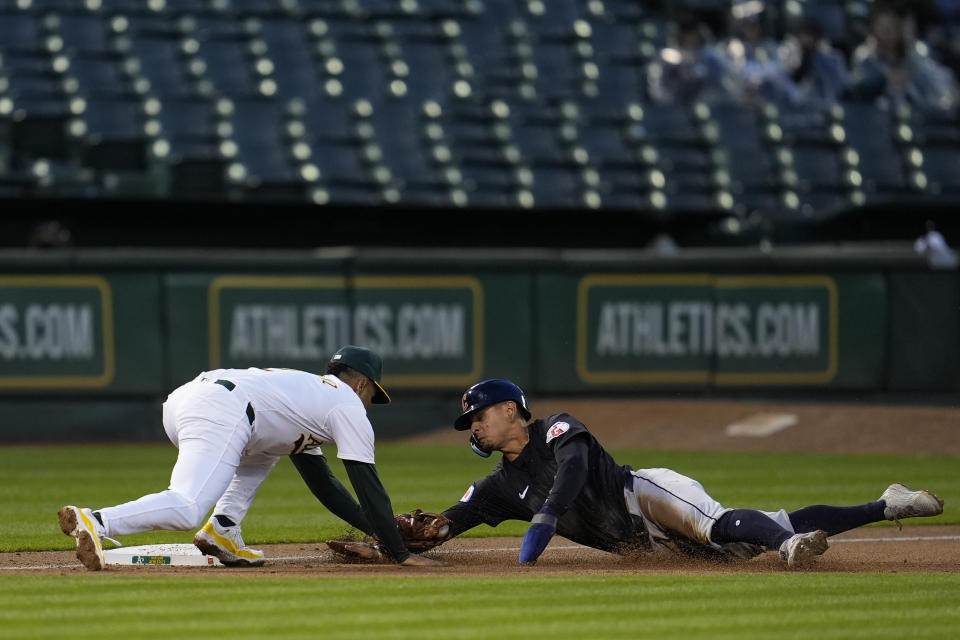 Oakland Athletics third baseman Darell Hernaiz, left, tags out Cleveland Guardians' Andres Giménez, who tried to advance on a single by Josh Naylor during the third inning of a baseball game Friday, March 29, 2024, in Oakland, Calif. (AP Photo/Godofredo A. Vásquez)