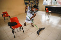 A mother mops the floor of a classroom before the students arrive for their first day of class since the COVID-19 outbreak, at the Valentin Gomez Farias Indigenous Primary School in Montebello, Hecelchakan, Campeche state, Monday, April 19, 2021. Campeche is the first state to transition back to the classroom after a year of remote learning due to the pandemic. (AP Photo/Martin Zetina)