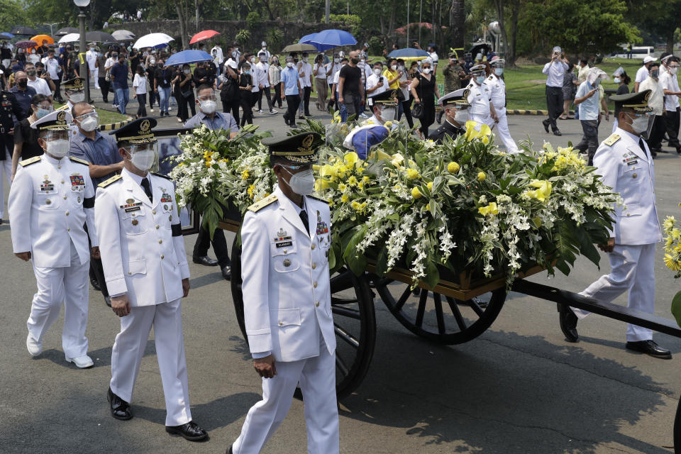 The urn of former Philippine President Benigno Aquino III is transported during state burial rites on Saturday, June 26, 2021 at a memorial park in suburban Paranaque city, Philippines. Aquino was buried in austere state rites during the pandemic Saturday with many remembering him for standing up to China over territorial disputes, striking a peace deal with Muslim guerrillas and defending democracy in a Southeast Asian nation where his parents helped topple a dictator. He was 61. (AP Photo/Aaron Favila)