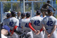 Former Los Angeles Dodgers player Reggie Smith, third from left, speaks along with Ayo Robinson, second from right, the granddaughter of baseball great Jackie Robinson, as Dodgers and Washington Nationals team members join in a celebration for Jackie Robinson Day before a game at Dodgers Stadium in Los Angeles, Monday, April 15, 2024. (AP Photo/Damian Dovarganes)