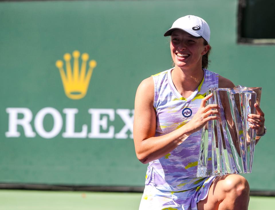 Iga Swiatek of Poland poses with her trophy after winning the WTA singles title at the BNP Paribas Open at the Indian Wells Tennis Garden in Indian Wells, Calif., Sunday, March 20, 2022. 