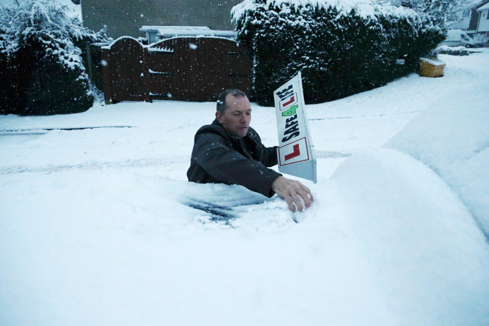 STOURBRIDGE, ENGLAND - DECEMBER 28: Driving instructor Steve Smith removes snow off the top of his car as heavy snowfall falls down on the west midlands overnight on December 28, 2020 in Stourbridge, England. (Photo by Cameron Smith/Getty Images)