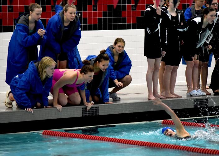 Dundee teammates yell encouragement to Sara Carter in the individual medley. Carter won the event at the Monroe County Swim Finals Saturday.