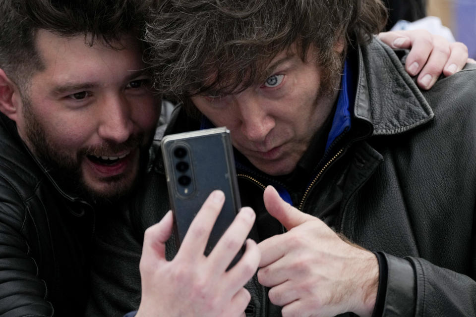 Presidential hopeful of the Liberty Advances coalition Javier Milei, right, poses for a selfie with a follower during a campaign event in La Plata, Argentina, Tuesday, Sept. 12, 2023. General elections are set for October 22.(AP Photo/Natacha Pisarenko)