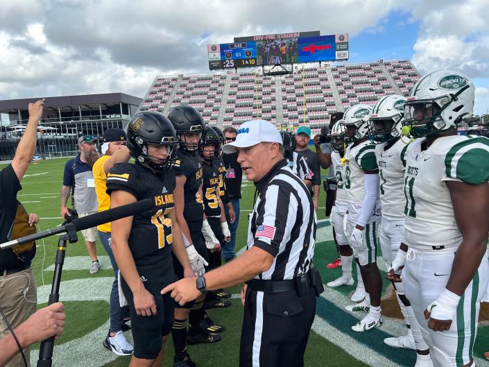 Players from Merritt Island and Miami Central meet for the coin toss in the 5A final.