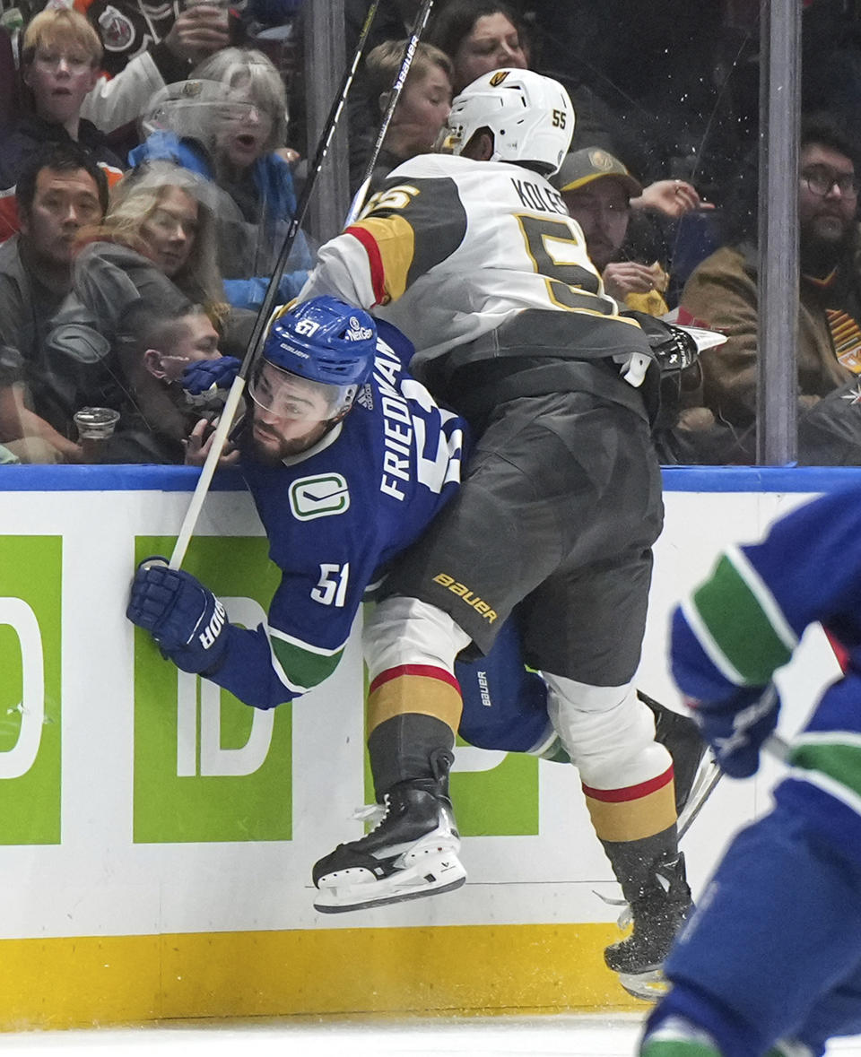 Vegas Golden Knights' Keegan Kolesar, right, checks Vancouver Canucks' Mark Friedman during the second period of an NHL hockey game Thursday, Nov 30, 2023, in Vancouver, British Columbia. (Darryl Dyck/The Canadian Press via AP)