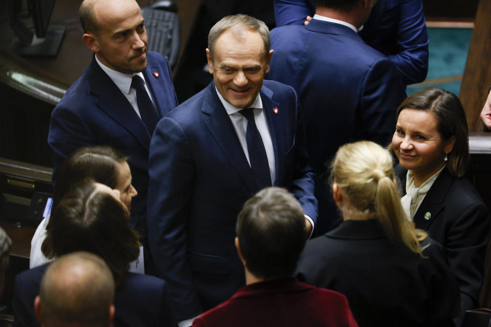 The leader of Poland's opposition Donald Tusk, center, reacts after Poland's Prime Minister Mateusz Morawiecki losing confidence vote at the parliament in Warsaw, Poland, Monday Dec. 11, 2023. Polish Prime Minister Mateusz Morawiecki's government lost the confidence vote in parliament, ending the rule of his national conservative party after eight years in power. (AP Photo/Michal Dyjuk)