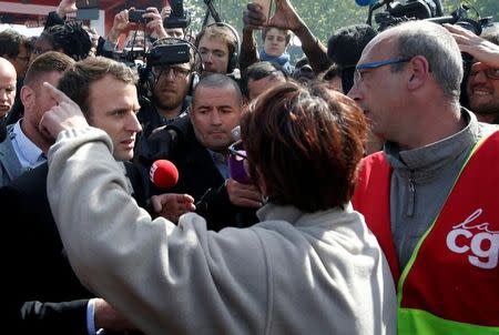 Emmanuel Macron (L), head of the political movement En Marche !, or Onwards !, and candidate for the 2017 French presidential election, is surrounded by journalists as he talks to Whirlpool employees in front of the company plant in Amiens, France, April 26, 2017. REUTERS/Pascal Rossignol