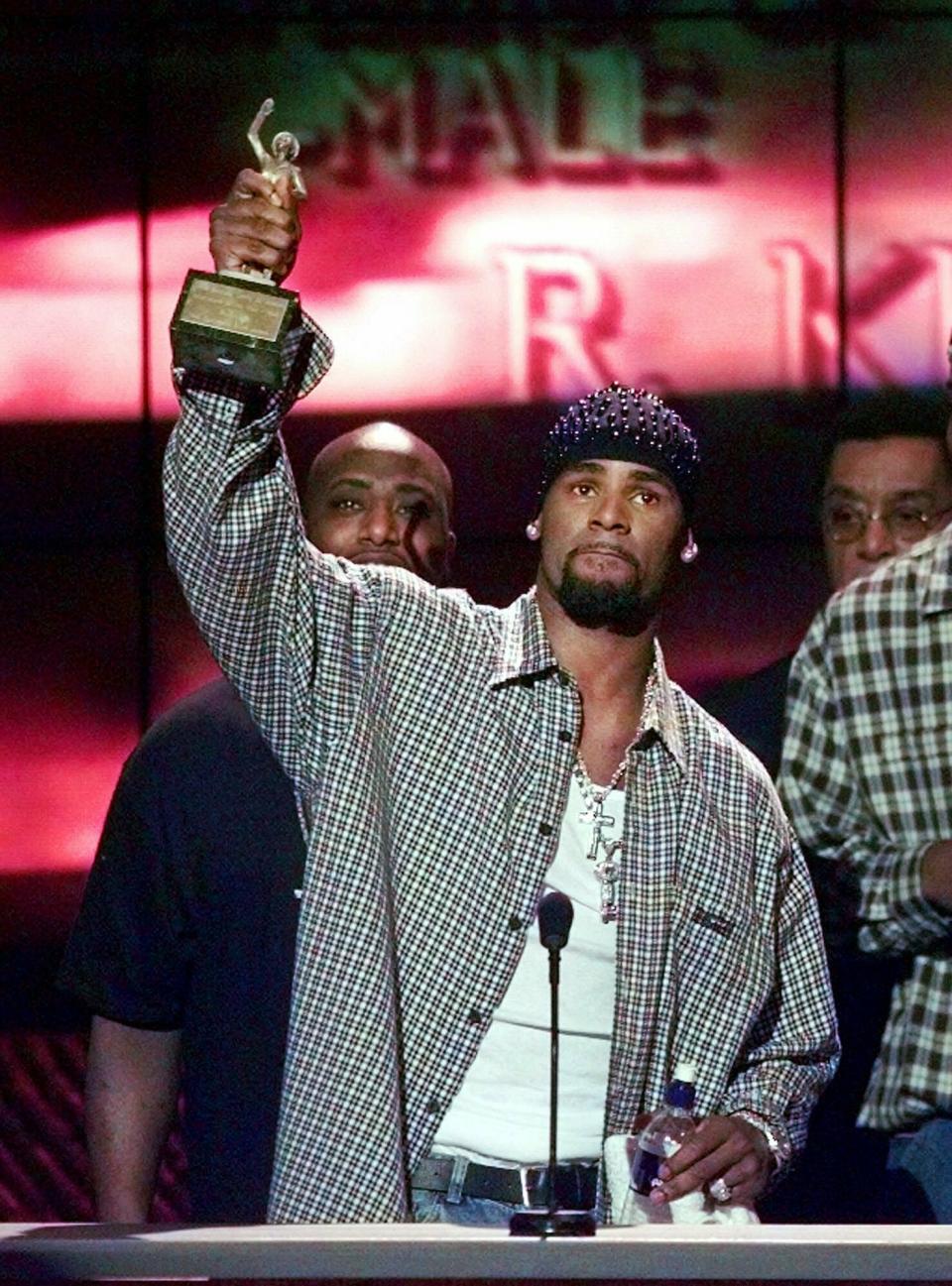 FILE - In this March 26, 1999 file photo, R. Kelly accepts the Sammy Davis Jr. Award for Male "Entertainer of the Year" at the 13th annual Soul Train Music Awards in Los Angeles. Kelly, one of the top-selling recording artists of all time, has been hounded for years by allegations of sexual misconduct involving women and underage girls _ accusations he and his attorneys have long denied. But an Illinois prosecutor’s plea for potential victims and witnesses to come forward has sparked hope among some advocates that the R&B star might face new charges. (AP Photo/Mark J. Terrill, File)