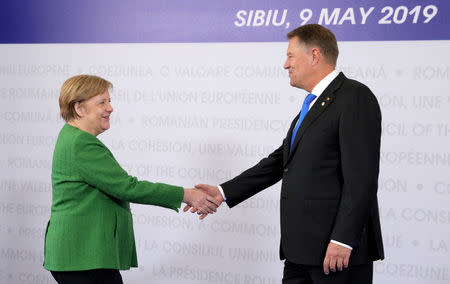 German Chancellor Angela Merkel is welcomed by Romanian President Klaus Iohannis as she arrives for the informal meeting of European Union leaders in Sibiu, Romania, May 9, 2019. REUTERS/Stoyan Nenov